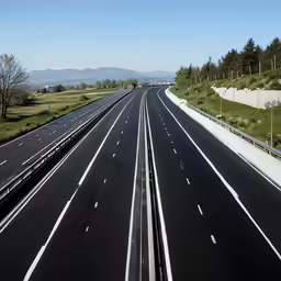 an empty freeway with the view of mountains