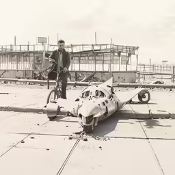 a man on a bike is next to an abandoned airplane