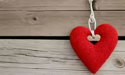an image of a wooden heart hanging on a rope