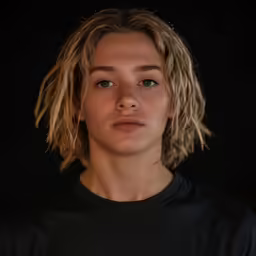 a woman with blond hair standing up in front of a black background