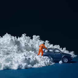 a toy man that is standing near some snow