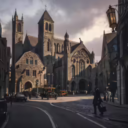 the people are walking down the street outside of a large building