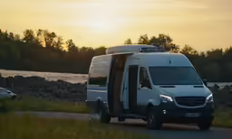 the mercedes benz van is driving down the road