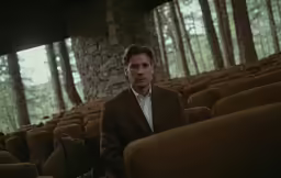 a man sitting on a chair in a theater
