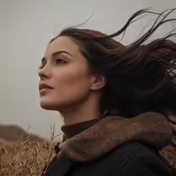 a woman is standing in a field of tall grass