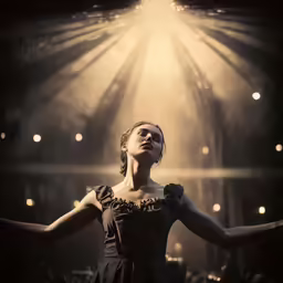 a lady that is standing on stage looking upwards