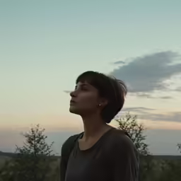 a woman is looking up while standing outside