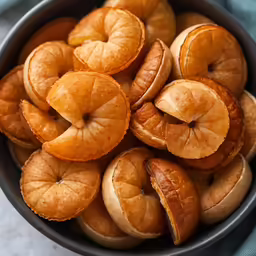 orange slices in a metal bowl on top of a table