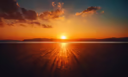 a sunset is pictured over a sandy beach
