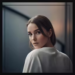 a woman in white with her hair tied into an updo and wearing earrings