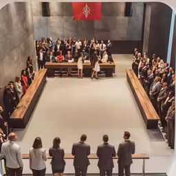 people sit at a lecture hall and look towards an auditorium