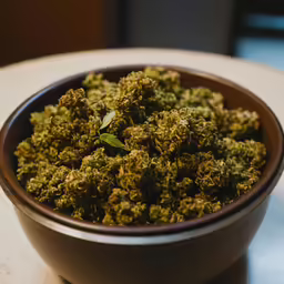 a brown bowl with some green flowers in it