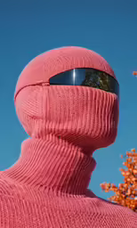 a close up view of a person with a pink scarf covering their head