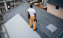 a man standing on top of a building next to a couple of windows