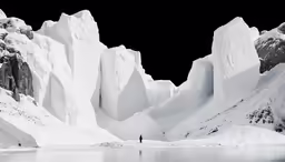 a snowy mountain range near water with ice formations