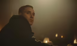 a man is staring ahead while sitting at a table