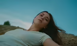 a woman is laying down in the sand