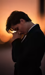 a woman in a suit looking down at her nose