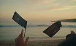 someone holds their camera while another holds the screen with a phone
