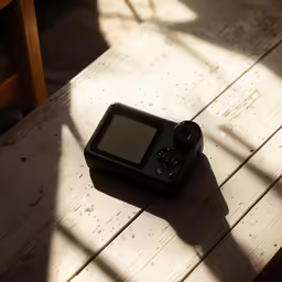 a camera sitting on a table with its reflection off the screen