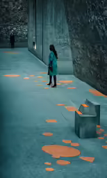 a woman stands in an outdoor space with a cement bench and concrete benches