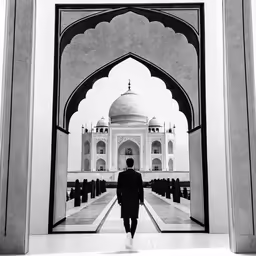 man walking through entrance into an arch in india