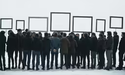 a group of people standing outside in the snow with empty frames above their heads
