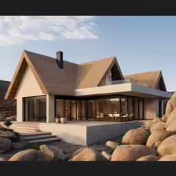 a modern white house on rocks near a large mountain