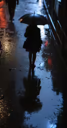 a woman holding an umbrella while walking down a street