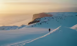 a person standing on top of a snow covered slope