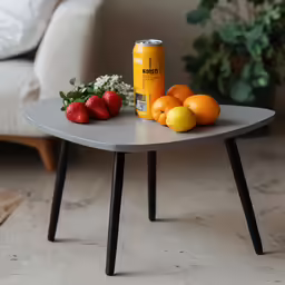 a small table has fruit and an orange on it
