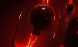 the red light is illuminating on top of the wine glass