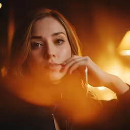young female with hand under chin while sitting down