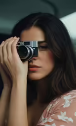 a woman holding a camera up against her face