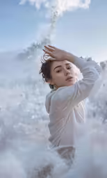 young girl with hand in hair blowing out water