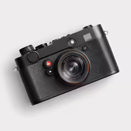 a camera on a white surface next to an ipod