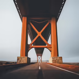 the underside of a long bridge that goes across a road