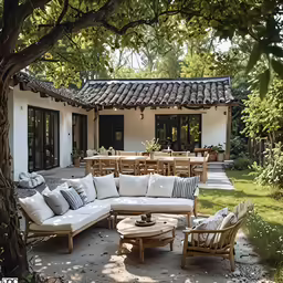 the patio of a house with a large table, couch and chair