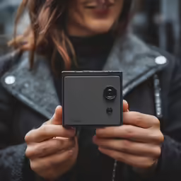 a woman holding up her camera in the street