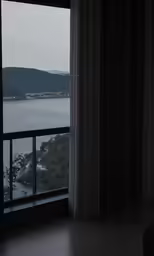 a dark view of the ocean seen from a bedroom window