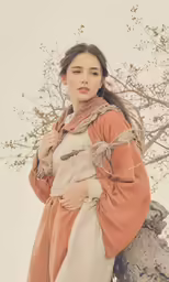 a woman is wearing a brown jacket with long sleeves