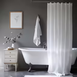 an elegant bathroom with gray walls and white fixtures