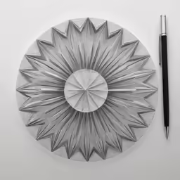 an artistically designed paper plate is displayed next to a pen