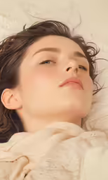 a woman has her eyes closed and she is in bed with her eyes closed and a blanket on her back
