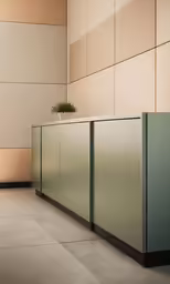 a long silver counter sits near a wall with large tiles
