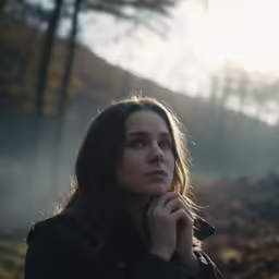 a woman in the fog looks up into the sky