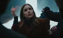 a woman in a red coat smoking a cigarette
