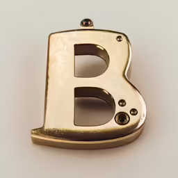 gold plated metal alphabet letter shaped brooch on white background
