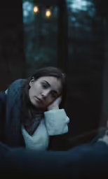 a woman in a jacket leaning against the arm of another person