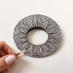 someone with a brush holding an object to the side of the image